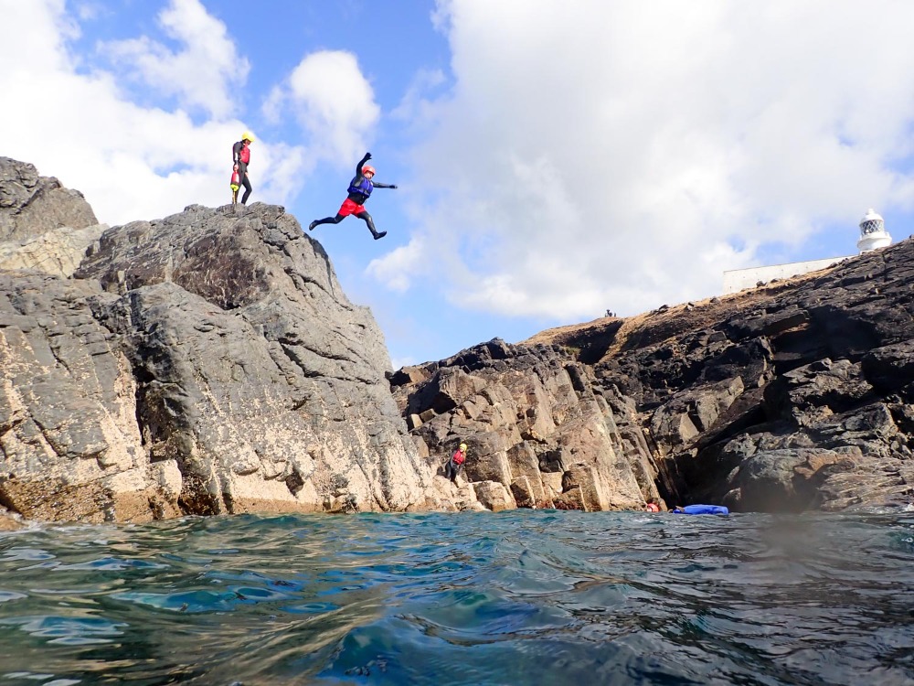 Coasteering cliff jump into the sea in Cornwall